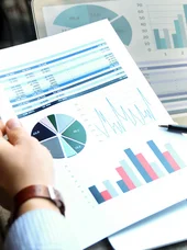 kommunale-finanzen-und-abgaben-c-saklakova-adobestock Detailansicht einer Finanzauswertung mit Kreisdiagramm, Balkendiagramm und Zahlentabellen neben Laptop