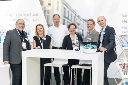 Messe KOMMUNAL Erfurt Kolleginnen und Kollegen des vhw stehen freundlich lächelnd an ihrem Messestand.