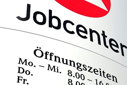 Foto: Schild eines Jobcenters mit Öffnungszeiten